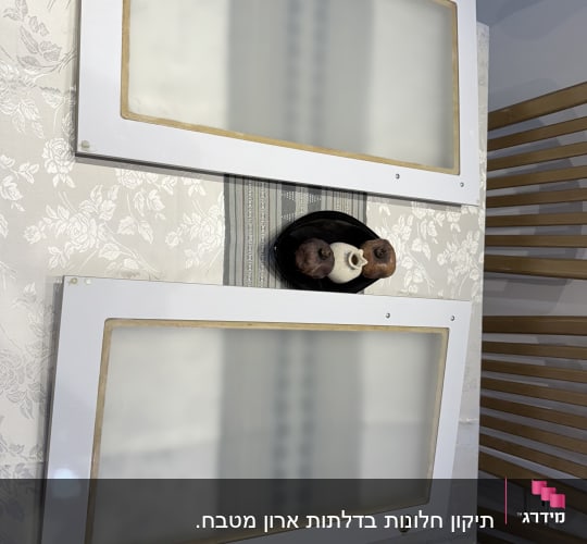 שני לוחות זכוכית עם מסגרת לבנה על רקע פרחוני